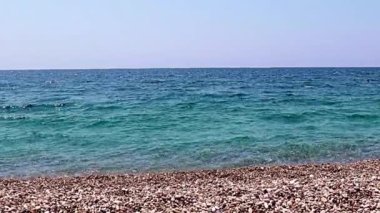 Aktif eğlence için güzel dalgalar ve çakıl taşlı deniz plajı