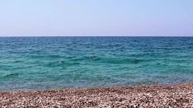 Aktif eğlence için güzel dalgalar ve çakıl taşlı deniz plajı