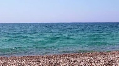 Aktif eğlence için güzel dalgalar ve çakıl taşlı deniz plajı
