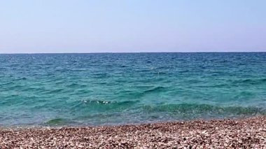 Aktif eğlence için güzel dalgalar ve çakıl taşlı deniz plajı