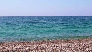 Aktif eğlence için güzel dalgalar ve çakıl taşlı deniz plajı