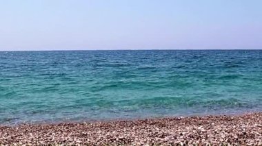 Aktif eğlence için güzel dalgalar ve çakıl taşlı deniz plajı