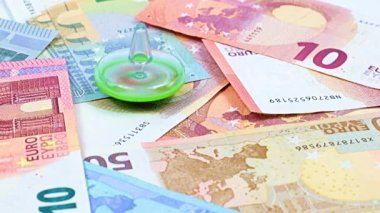 Finansal piyasanın sürdürülebilirliğinin bir sembolü olarak çocuk plastik oyuncağının kağıt para yığınının üzerinde dönmesi.