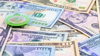 Finansal piyasanın sürdürülebilirliğinin bir sembolü olarak bir yığın kağıt doların üzerinde bir çocuk plastik oyuncağının dönüşü.