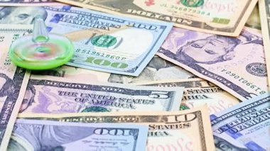 Finansal piyasanın sürdürülebilirliğinin bir sembolü olarak bir yığın kağıt doların üzerinde bir çocuk plastik oyuncağının dönüşü.