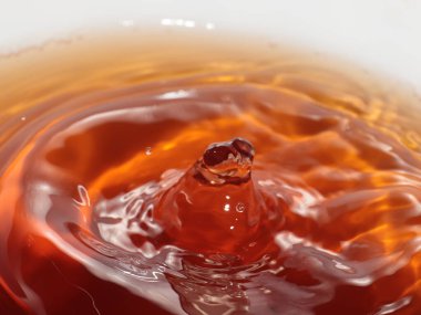 Sert bir içki damlası bir sıvının yüzeyine düşer.