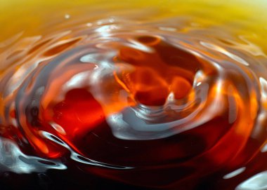 Sert bir içki damlası bir sıvının yüzeyine düşer.