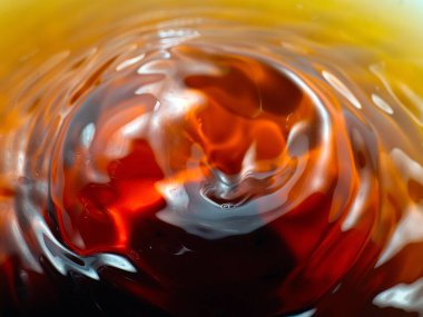 Sert bir içki damlası bir sıvının yüzeyine düşer.