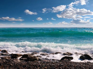 Güzel çakıl taşı plajı ve tatil köyündeki bulutlu gökyüzü.