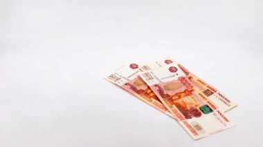 Beş bin ruble değerinde bir yığın Rus kağıt banknotunun içine düşüyorlar.