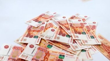 Beş bin ruble değerinde bir yığın Rus kağıt banknotunun içine düşüyorlar.