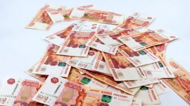 Beş bin ruble değerinde bir yığın Rus kağıt banknotunun içine düşüyorlar.