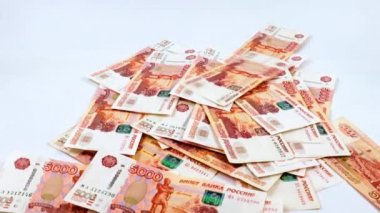 Beş bin ruble değerinde bir yığın Rus kağıt banknotunun içine düşüyorlar.