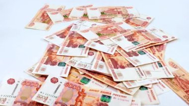 Beş bin ruble değerinde bir yığın Rus kağıt banknotunun içine düşüyorlar.