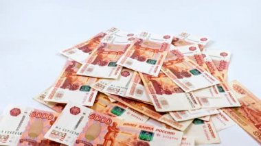 Beş bin ruble değerinde bir yığın Rus kağıt banknotunun içine düşüyorlar.