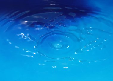 Düşerken bir damla saf saydam su sıvıda desenler oluşturur.