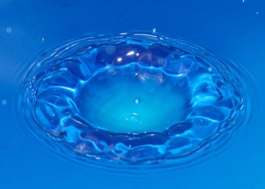 Düşerken bir damla saf saydam su sıvıda desenler oluşturur.