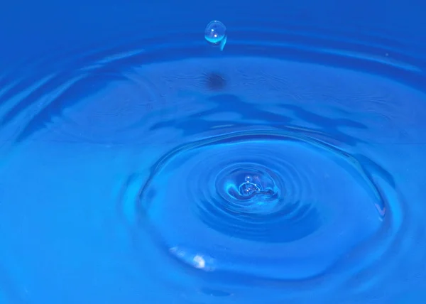 跌落时一滴纯净透明的水在液体上形成花纹 — 图库照片