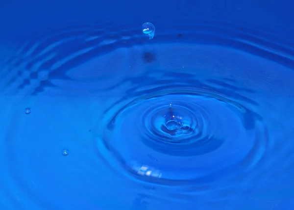 跌落时一滴纯净透明的水在液体上形成花纹 — 图库照片