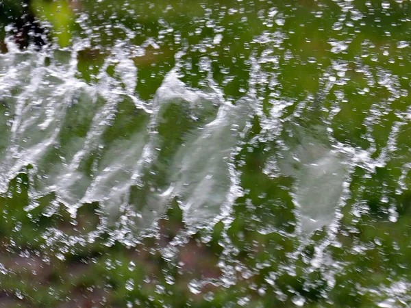 緑の芝生の背景に水をやると — ストック写真