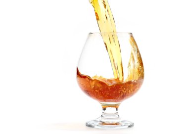 Bardağa doldurulan güçlü bir alkollü içeceğin inanılmaz güzel bukleleri.