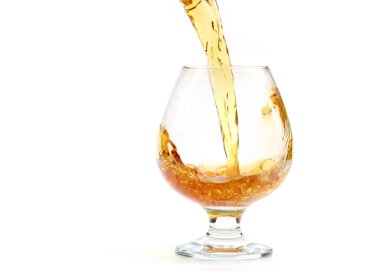 Bardağa doldurulan güçlü bir alkollü içeceğin inanılmaz güzel bukleleri.