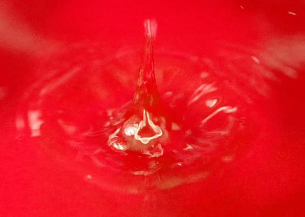 Een Druppel Bloedrode Vloeistof Valt Het Wateroppervlak — Stockfoto