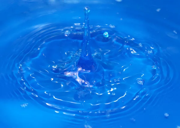 一滴纯净透明的水落在液体表面 — 图库照片