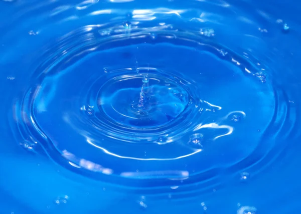 一滴纯净透明的水落在液体表面 — 图库照片