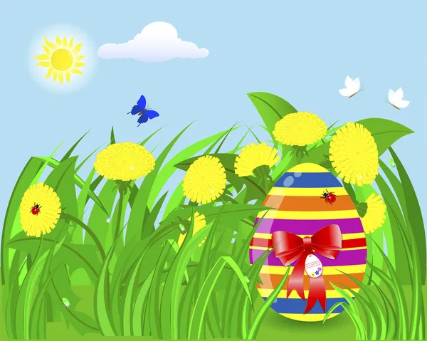 Easter egg in the grass with yellow dandelions.
