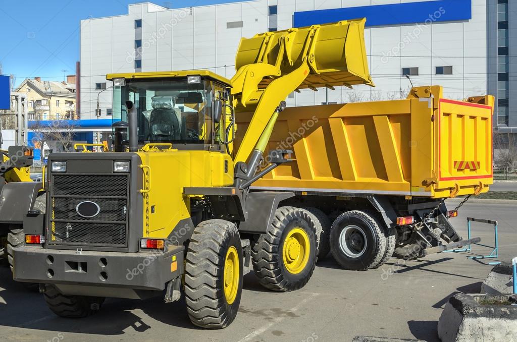 Front loader loading the truck (all logos, inscriptions and markings removed)