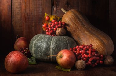 Elma ve balkabağı siyah ahşap bir zemin üzerinde kırsal bir tarzda