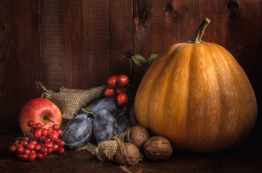 kabak ve diğer meyveler koyu ahşap bir zemin üzerinde kırsal bir tarzda