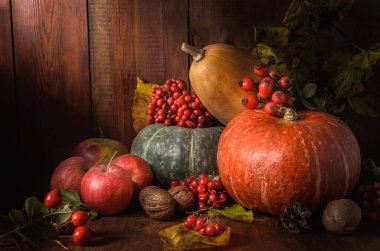 Elma ve balkabağı siyah ahşap bir zemin üzerinde kırsal bir tarzda