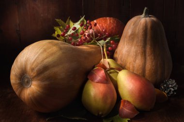 Olgun armutlar ve kabak koyu ahşap bir zemin üzerinde kırsal bir tarzda