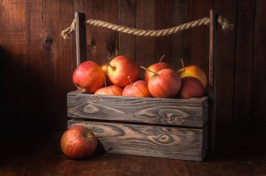 Koyu ahşap arka plandaki elmalar kırsal tarzda