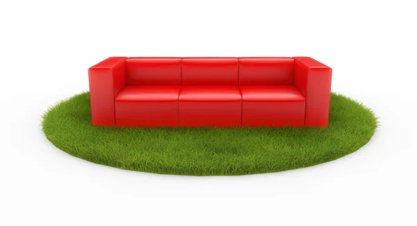 Красный диван на зеленом поле — стоковое фото