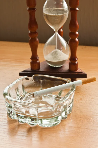 Hourglass and a cigarette — Stock Photo, Image