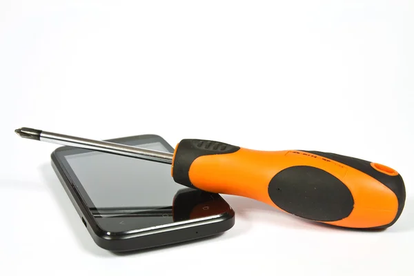 Screwdriver and a cell phone — Stock Photo, Image