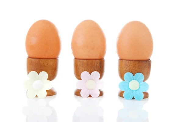 Tres huevos de gallina en fila en soportes de madera —  Fotos de Stock