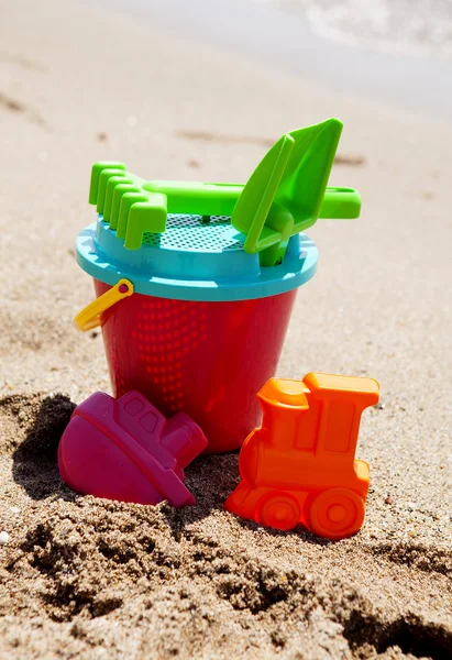 Los juguetes de plástico en la playa —  Fotos de Stock
