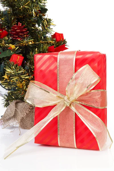 Presente de Natal com grande arco dourado no fundo branco — Fotografia de Stock