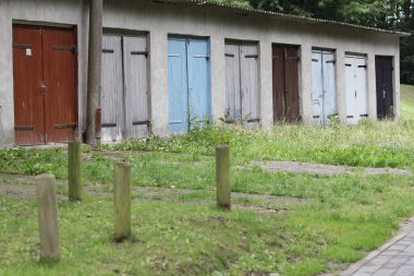 Farklı renkte kapıları olan düz, uzun bir bina.