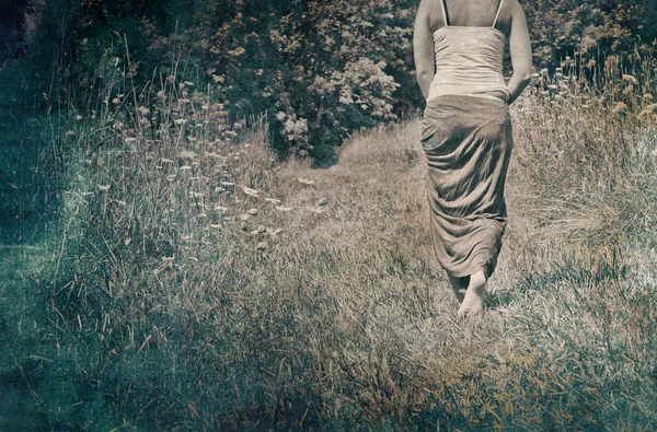 Young woman walking away in nature — Stock Photo, Image