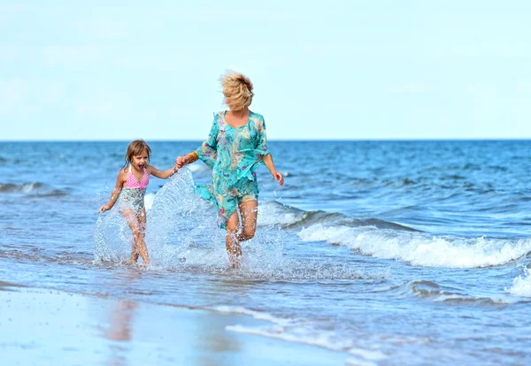 Moeder met dochter op strand — Stockfoto