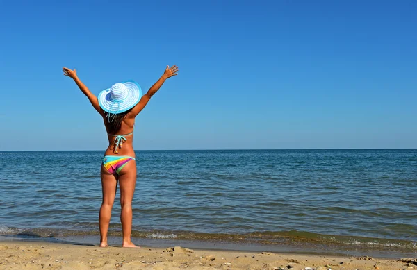 Een vrouw die over het strand loopt — Stockfoto