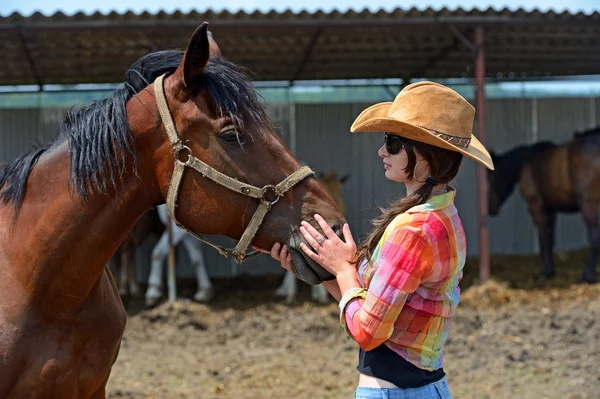 Mooi meisje met een paard op een boerderij — Stockfoto