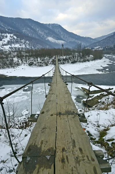 Suspension bridge across mountain river — Stock Photo, Image