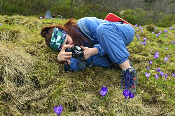Girl on a mountain photographing flowers — Stock Photo, Image