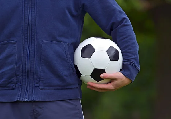 Bola de futebol na mão — Fotografia de Stock